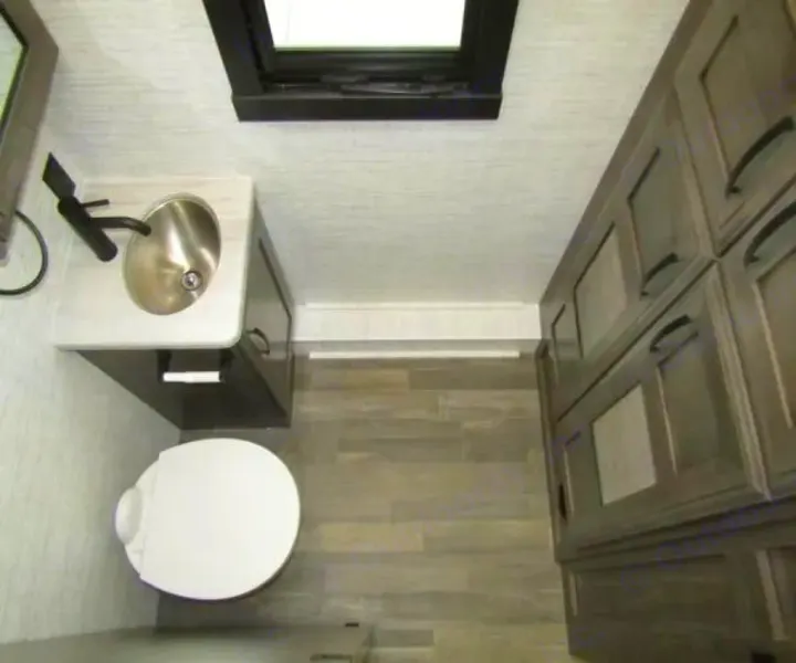 Overhead view of a compact RV rental bathroom: sink, toilet, and ample storage cabinets.. Jayco Precept 2025