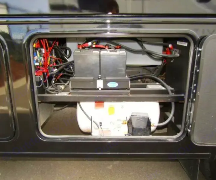 Inside an RV rental compartment: batteries, complex wiring for electrical power, and a water tank with pump, ready for adventure.. Jayco Precept 2025