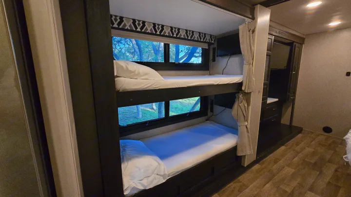 Experience comfort in this RV rental! Features clean, bright bunk beds with views of nature, plus a small TV area.. Entegra Coach Vision XL 2021
