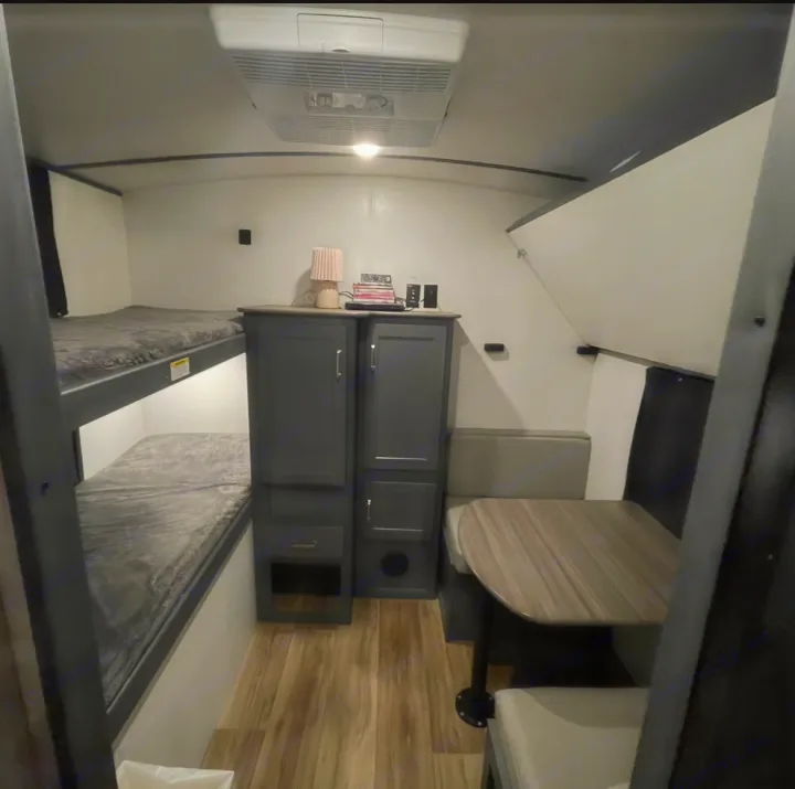 RV rental interior featuring cozy bunk beds, a convenient dinette, and storage. Perfect family adventure space.. Keystone RV Bullet Ultra Lite 2022