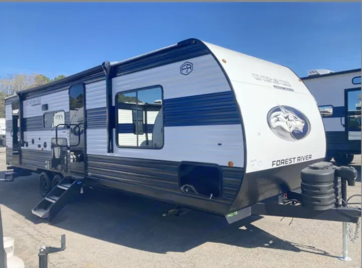 White and blue Forest River Cherokee travel trailer, with steps down, ready for your next rv rental adventure outdoors.. Forest River Cherokee Grey Wolf 2026