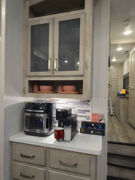 Modern RV rental interior featuring a built-in coffee station with Nespresso machine, air fryer, and stylish pink dishware.. Keystone RV Alpine Avalanche 2024