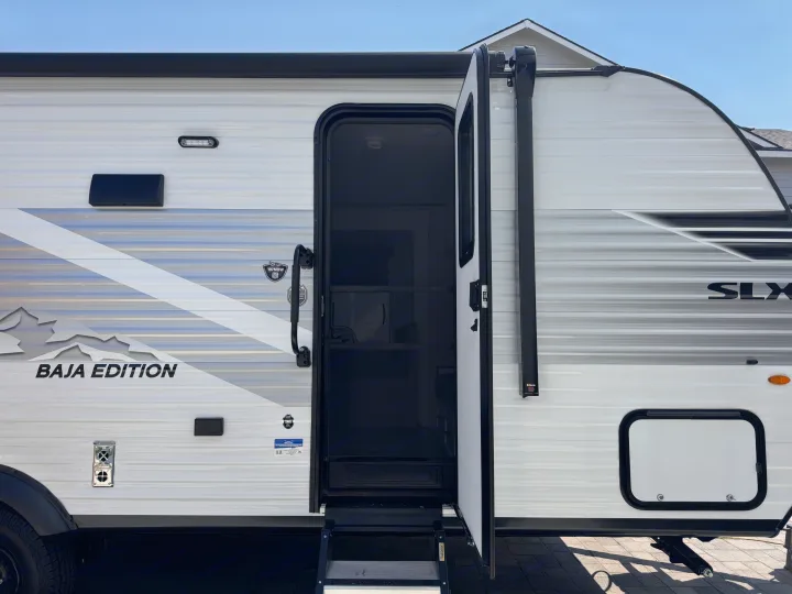 Side of a white Baja Edition RV rental camper with its door open, showing steps. SLX series is visible.. Jayco Jay Flight 2026