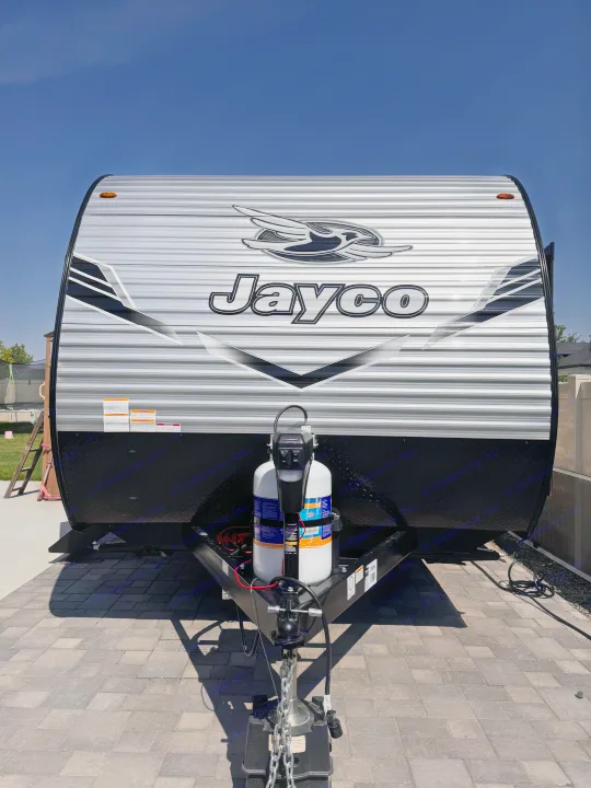 Head-on view of a Jayco travel trailer featuring silver corrugated siding, black trim, and front propane tanks. Ideal for an RV rental.. Jayco Jay Flight 2026