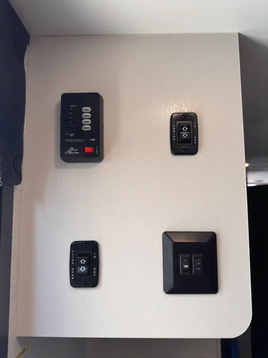 RV rental's interior control panel: monitor for tanks/battery, awning, slide room, and utility switches.. Jayco Jay Flight 2026