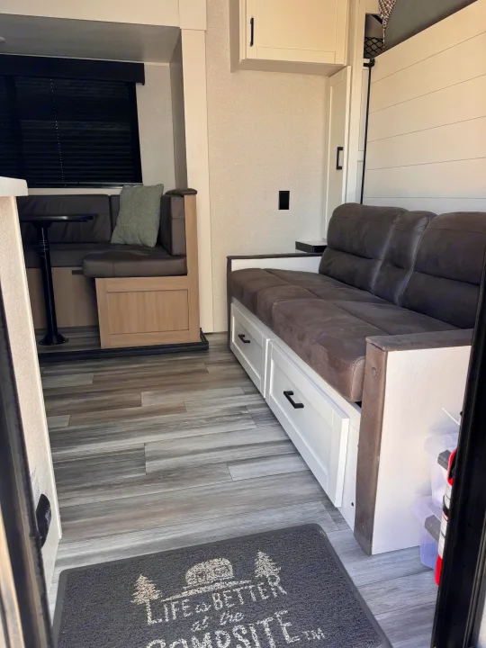 Step inside this clean RV rental featuring a dinette, sofa with drawers, and modern wood-look flooring.. Jayco Jay Flight 2026