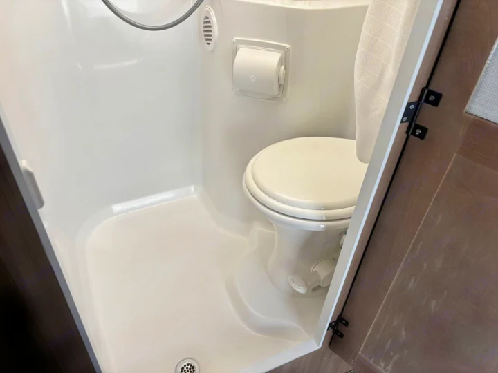 RV rental compact wet bath: all-in-one bathroom with white toilet, shower area, and drain for efficient use of space.. Adventurer 19RK113 2014