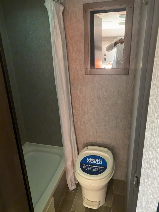 Compact RV rental bathroom with shower, toilet, and mirror, ready for your travels. Camping World certified clean.. Dutchmen Coleman Lantern LT 2020