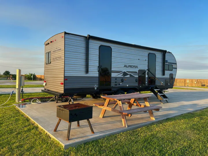 Ready for adventure: modern RV rental on a concrete pad with picnic table, grill, and full hookups.. Forest River 26FKDS 2025