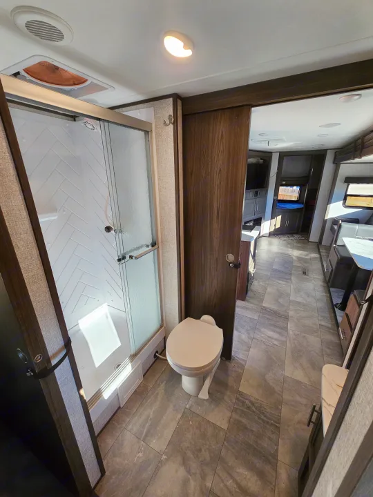 Step into this RV rental! View of the modern bathroom with a large shower and toilet, seamlessly connecting to the main living area.. Dutchmen Kodiak Ultra Lite 2021