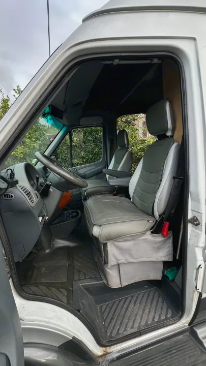 Get a feel for your next RV rental: a bright, well-maintained van interior with grey seats and rubber floor mats.. Airstream Interatate 2003