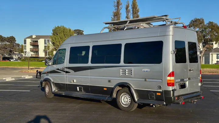 This silver Airstream Interstate camper van, equipped with solar panels, is ready for an rv rental getaway.. Airstream Interatate 2003