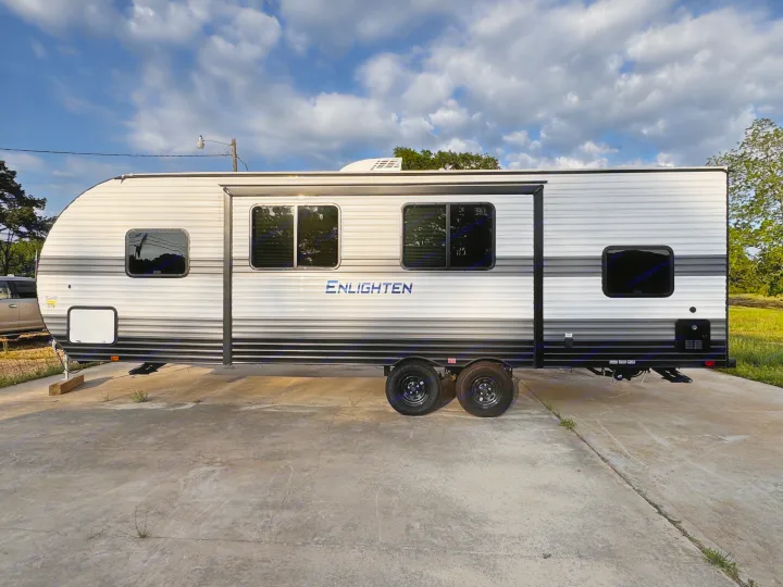 This RV rental, an Enlighten travel trailer, is parked outdoors on concrete under a cloudy sky.. Gulf Stream Enlighten 2025