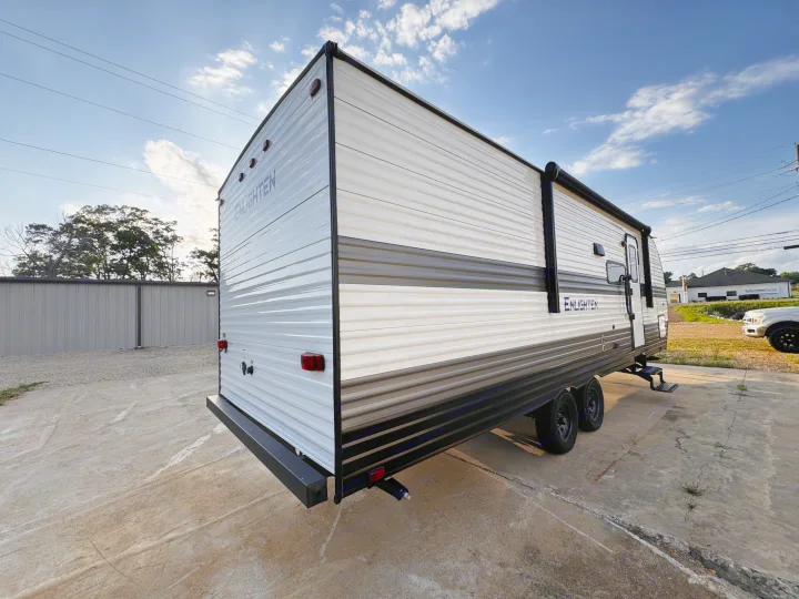 Enlighten travel trailer, a clean white & gray RV rental, parked on concrete. Ideal for your next outdoor adventure.. Gulf Stream Enlighten 2025