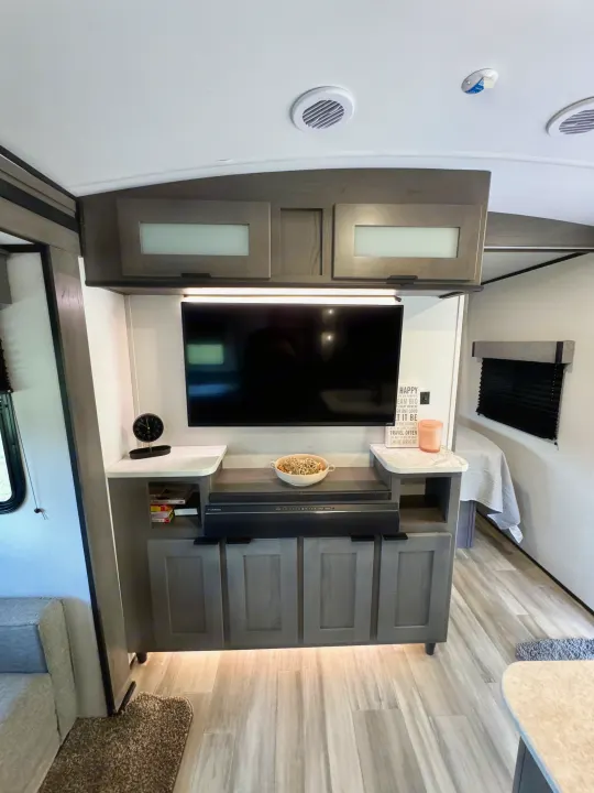 Modern RV rental interior: A well-appointed living space with TV, Furrion soundbar, and ample storage for comfortable travel.. Cruiser RV MPG Ultra Lite 2022