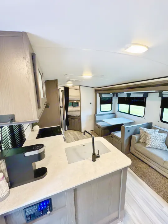 Spacious RV rental interior: modern kitchen, dinette, living area with sofa, and rear bunk beds for comfortable travels.. Cruiser RV MPG Ultra Lite 2022