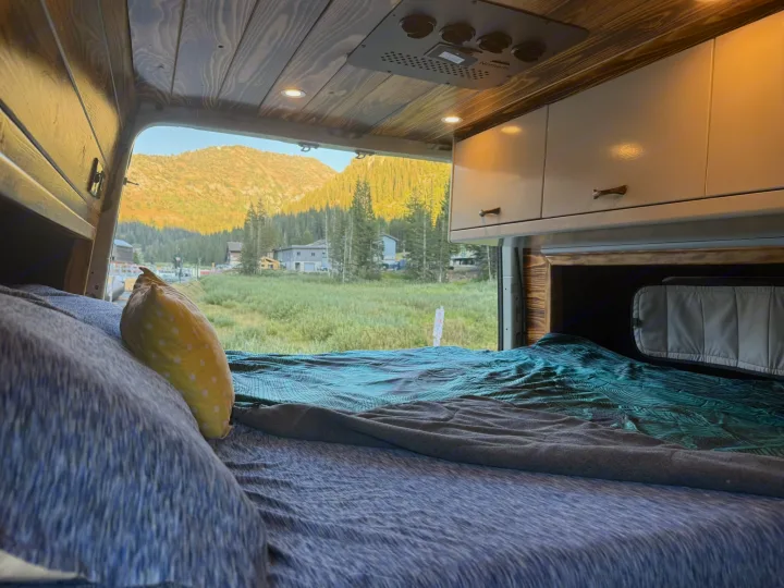 Relax in this cozy RV rental from a comfy bed, enjoying stunning mountain views and lush greenery perfect for van life camping.. Mercedes-Benz Sprinter 2019
