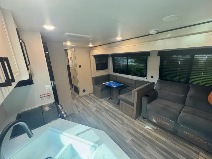 Inside an RV rental: a well-appointed kitchen, versatile dinette, and plush sofa in a bright, clean space.. Jayco Jay Jay Flight 294QBS 2025