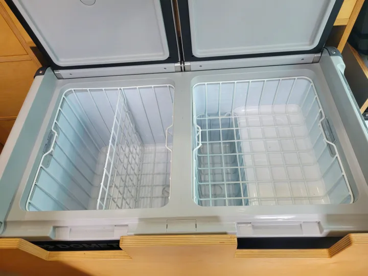 Open Dometic dual-zone portable fridge in an RV rental. Clean and empty with baskets, ready for your camping adventures.. Mercedes Sprinter 2006