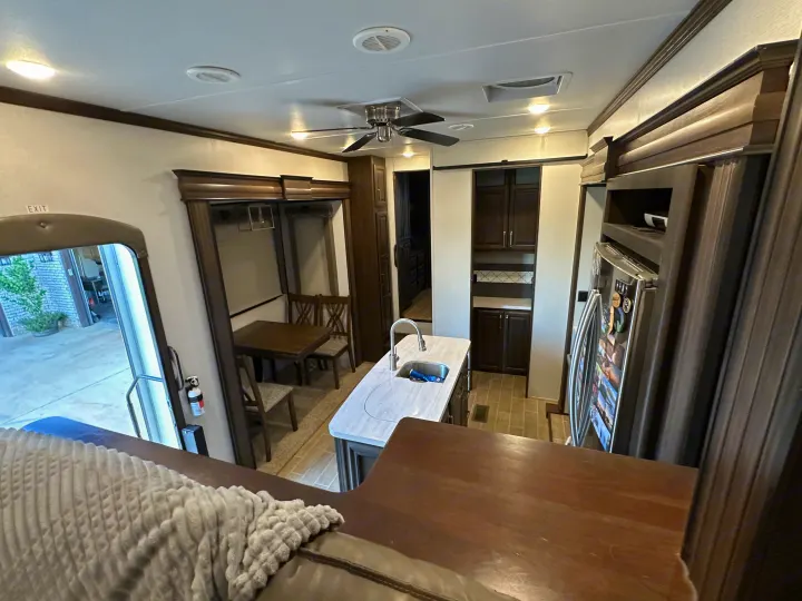 Explore this modern rv rental's spacious interior, featuring a full kitchen and comfy dining area.. Keystone RV Alpine 2021