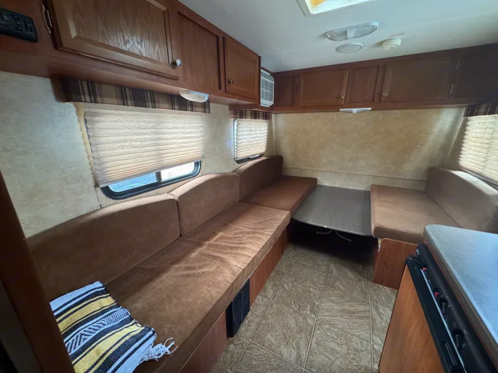 Spacious rv rental interior with comfortable seating, dining table, and kitchen area. Perfect for your next adventure.. Jayco Jay Flight Swift SLX 2012