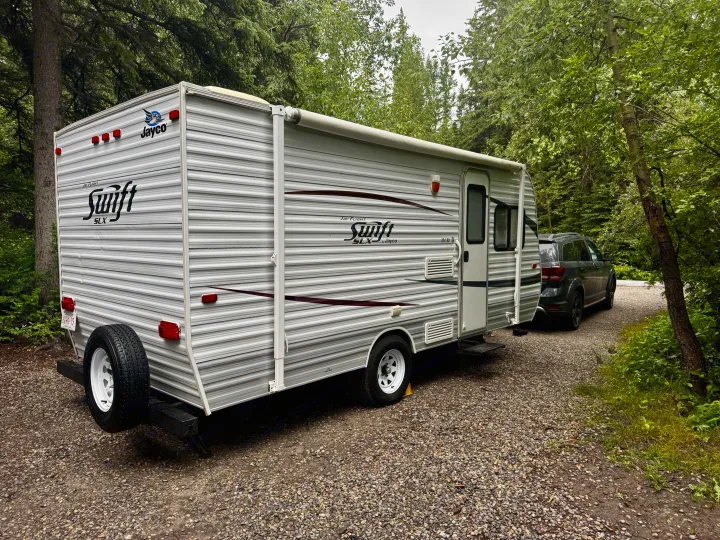 Jayco Swift SLX travel trailer RV rental & tow car on gravel in a green forest. Perfect for a nature getaway.. Jayco Jay Flight Swift SLX 2012