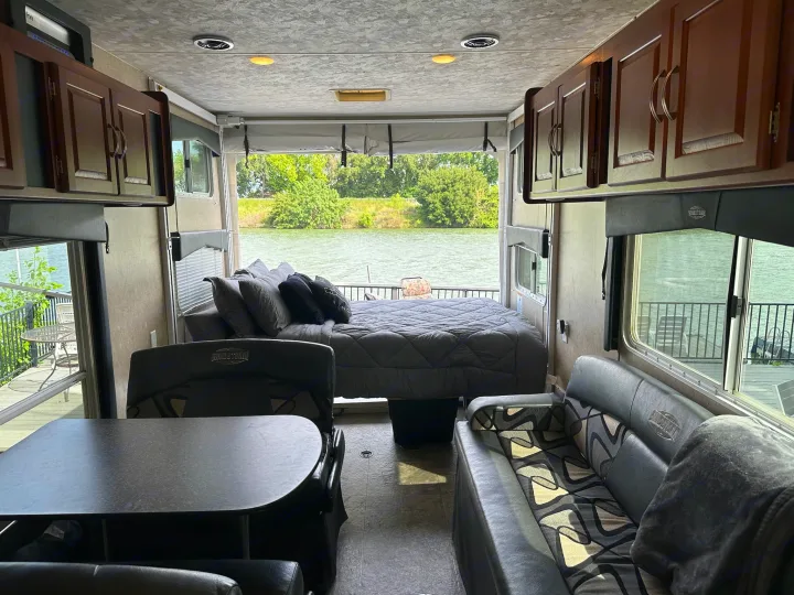 Enjoy lake views from this well-appointed RV rental interior, featuring a bed, dining, and lounge area.. Forest River Sandstorm 2012