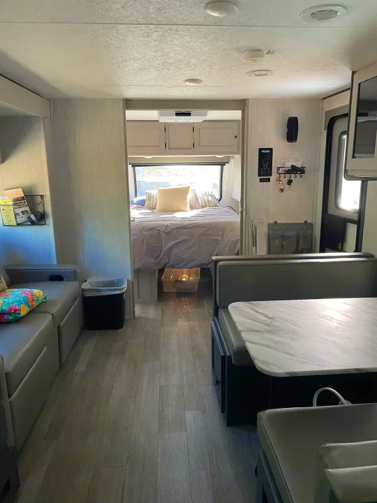 Spacious RV rental interior featuring a modern dinette, sofa, and bright bedroom with natural light.. Coachmen Apex 300 BHS 2025