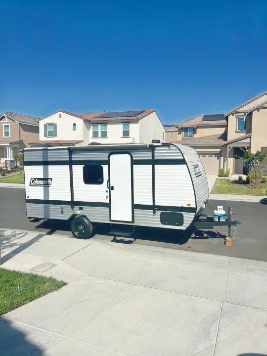 This new Coleman travel trailer, ideal for an **RV rental**, sits curbside, ready for a sunny road trip adventure. #Camping #Travel. Coleman Lantern 17B 2025