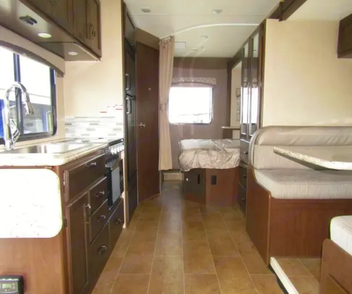 RV rental interior showing kitchen, dinette booth, and rear bed with ample space on tiled flooring.. Thor Chateau 2019