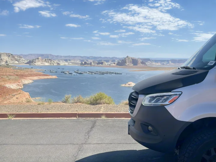 An RV rental offers stunning views of a vast desert lake, packed with boats, and framed by impressive rock formations.. Entegra Coach Launch 2023