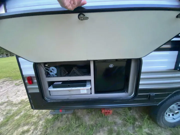 Discover the outdoor kitchen of this RV rental, featuring a mini-fridge, stovetop, and storage for your camping trips.. Dutchmen Coleman Lantern LT 2022