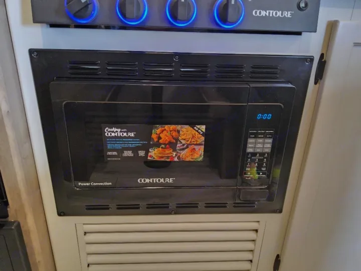 RV rental kitchen: Contoure microwave (air-fry/convection) and stove controls for convenient cooking with modern appliances.. Keystone Springdale Classic 2025