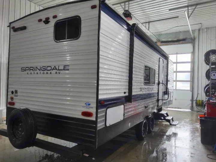 Detailing a Springdale Keystone RV rental. This white travel trailer is in a service bay, floor is wet.. Keystone Springdale Classic 2025