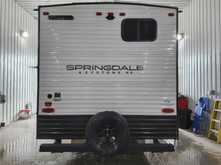 The back of a clean Springdale Keystone RV travel trailer with a spare tire, being prepped for your next RV rental.. Keystone Springdale Classic 2025