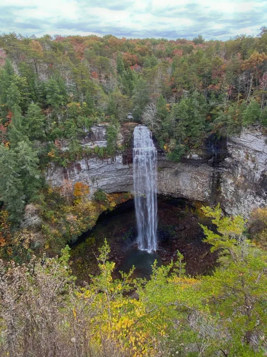Stunning waterfall plunges into a forested gorge, perfect for an RV rental adventure. Explore nature's beauty!. Forest River Cherokee 2021