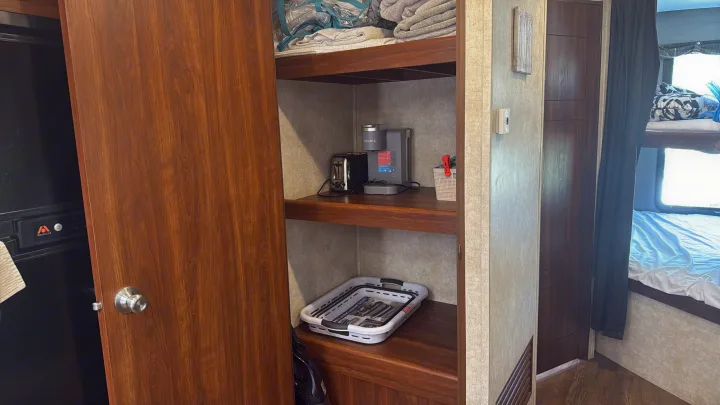 Compact RV rental interior with kitchen appliances (Keurig, toaster), organized storage, and bunk beds.. Keystone RV Bullet Premier 2015