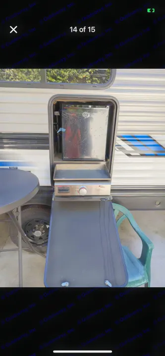 This RV rental features an outdoor kitchen setup with a griddle, mini-fridge, and pull-out counter.. Heartland RVs Pioneer 2023