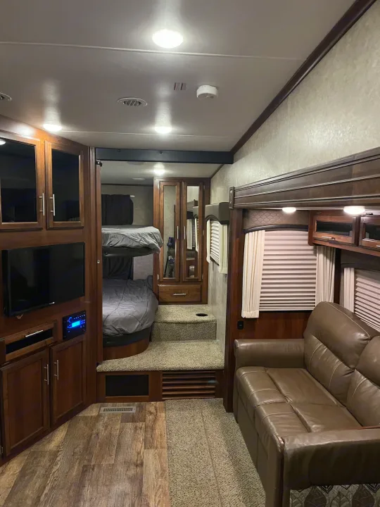 RV rental interior: inviting living area with leather sofa, entertainment system, plus cozy bunk beds. Great for family trips!. Jayco Eagle HT 2017