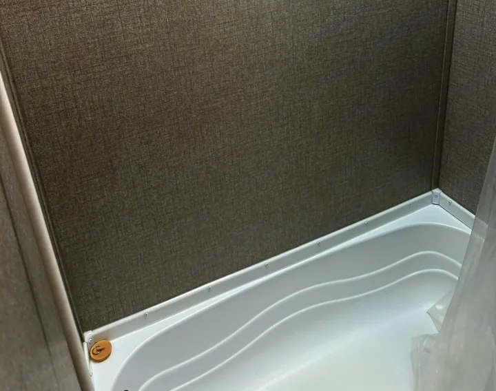 Compact RV rental shower/tub with gray textured walls and a white, stepped base. Perfect for travel adventures.. Jayco Jay Flight SLX 2021