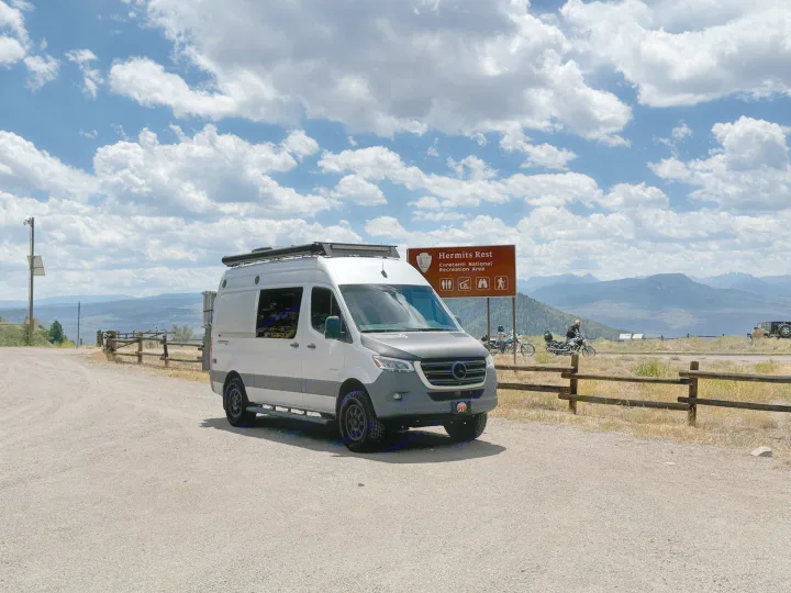 White RV rental (Sprinter van) at Hermits Rest, Curecanti National Recreation Area, offering scenic mountain views under cloudy skies.. Entegra Coach Launch 2023