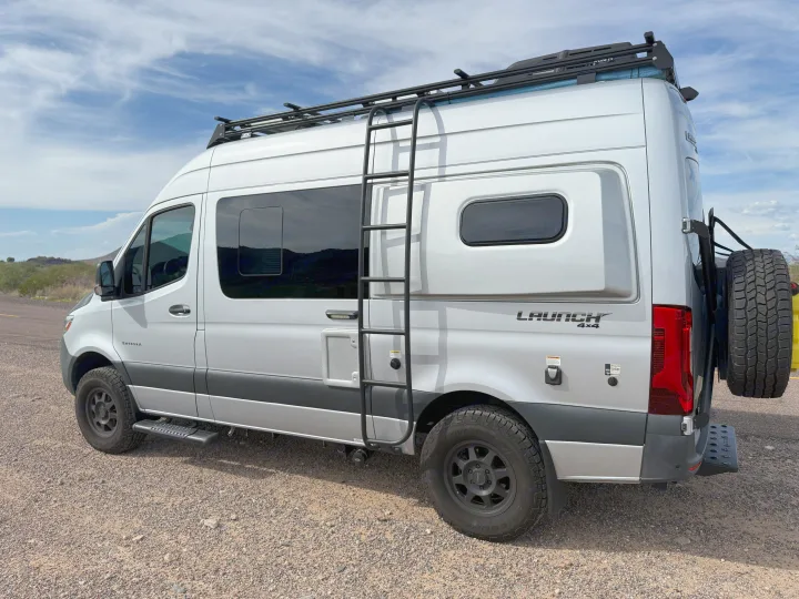 This silver Entegra Launch 4x4 RV rental, equipped with a roof rack and rugged tires, is ready for your next adventure.. Entegra Coach Launch 2023