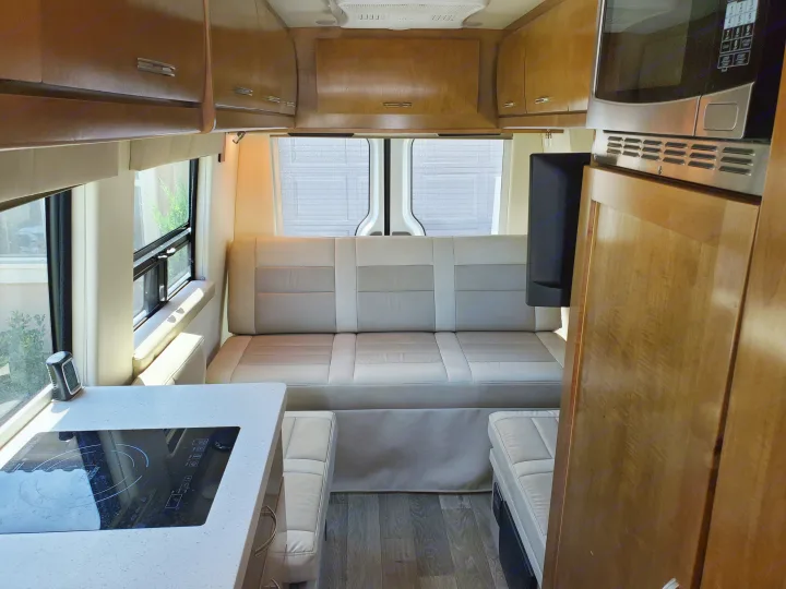 RV rental interior with a spacious rear seating area, well-equipped kitchenette with induction cooktop, microwave, and ample storage.. Coachmen Galleria 2019