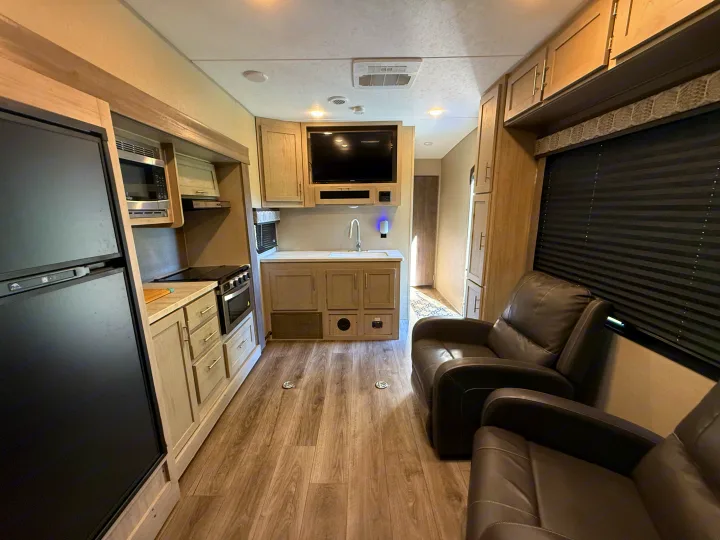Step inside this RV rental, featuring a complete kitchen, living area with recliners, and modern amenities.. Coachmen Catalina 2022