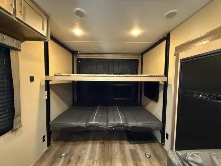 Experience this **rv rental's** versatile interior with convertible bunk beds and a refrigerator, offering flexible sleeping for travel.. Coachmen Catalina 2022