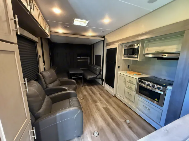 Modern RV rental: a bright interior with comfy recliners, full kitchen setup, and a spacious rear garage for your gear.. Coachmen Catalina 2022