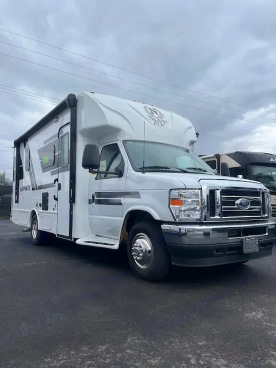 White Nexus Viper Class C rv rental, a Ford motorhome, parked on asphalt with its awning extended.. Nexus Viper 2026