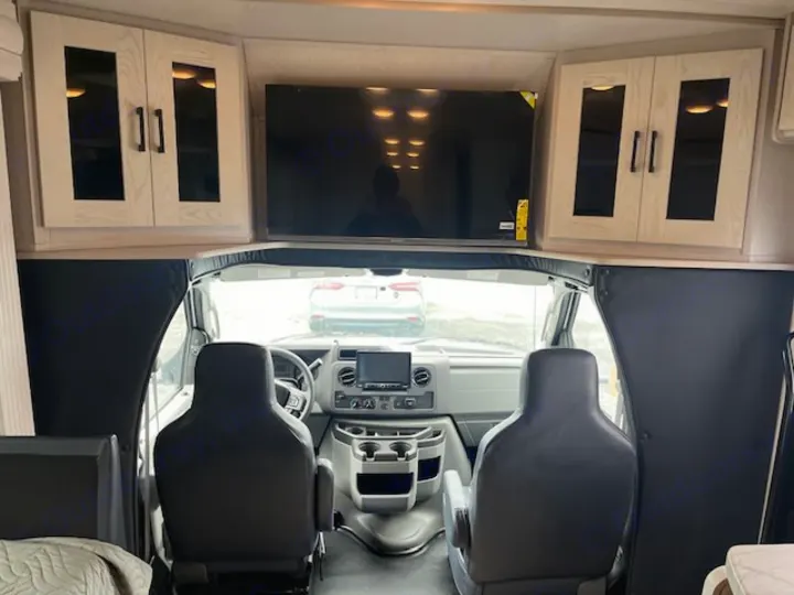 RV rental interior looking forward at the cockpit, driver/passenger seats, overhead storage, & TV. Ready for your trip!. Nexus Viper 2026