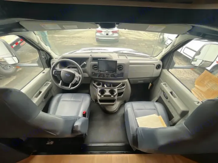 Spacious RV rental cockpit with Ford steering wheel, dashboard, infotainment screen, and gray front seats.. Nexus Viper 2026