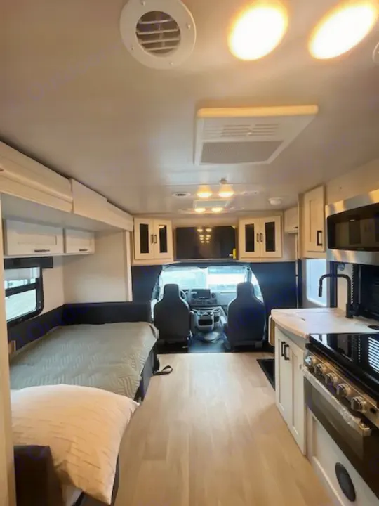 Modern RV rental interior showcasing a bed, fully equipped kitchen, and driver's area upfront.. Nexus Viper 2026